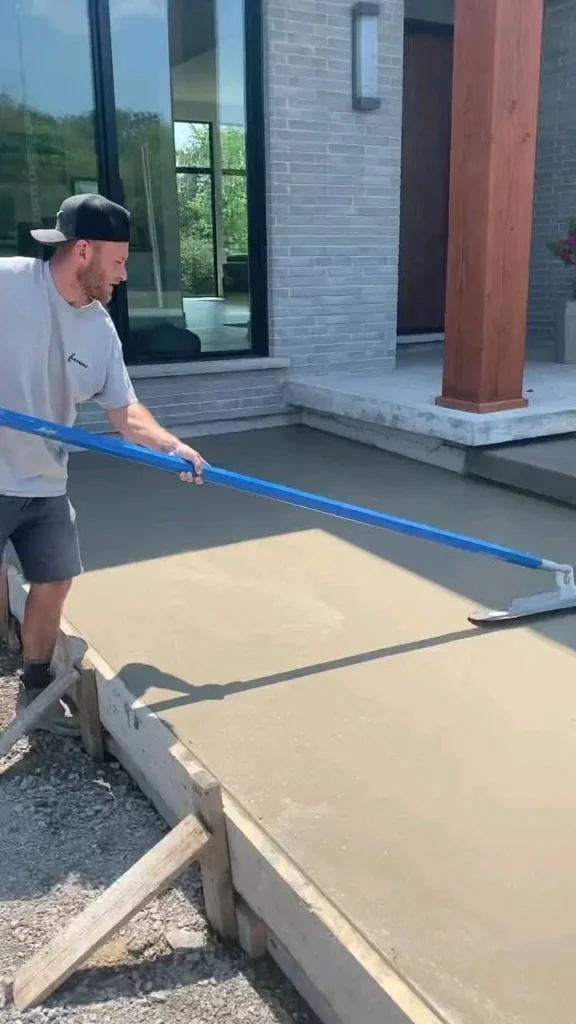 Basement concrete floor being poured and screeded during slab installation

