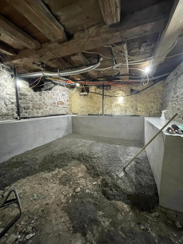 Basement concrete floor installation inside existing foundation with moisture control
