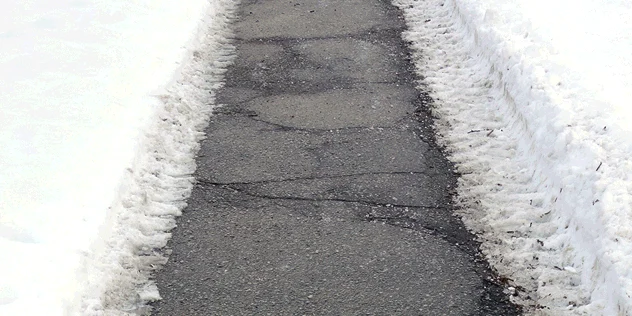 Concrete sidewalk in Calgary during winter showing freeze-thaw exposure and snow conditions
